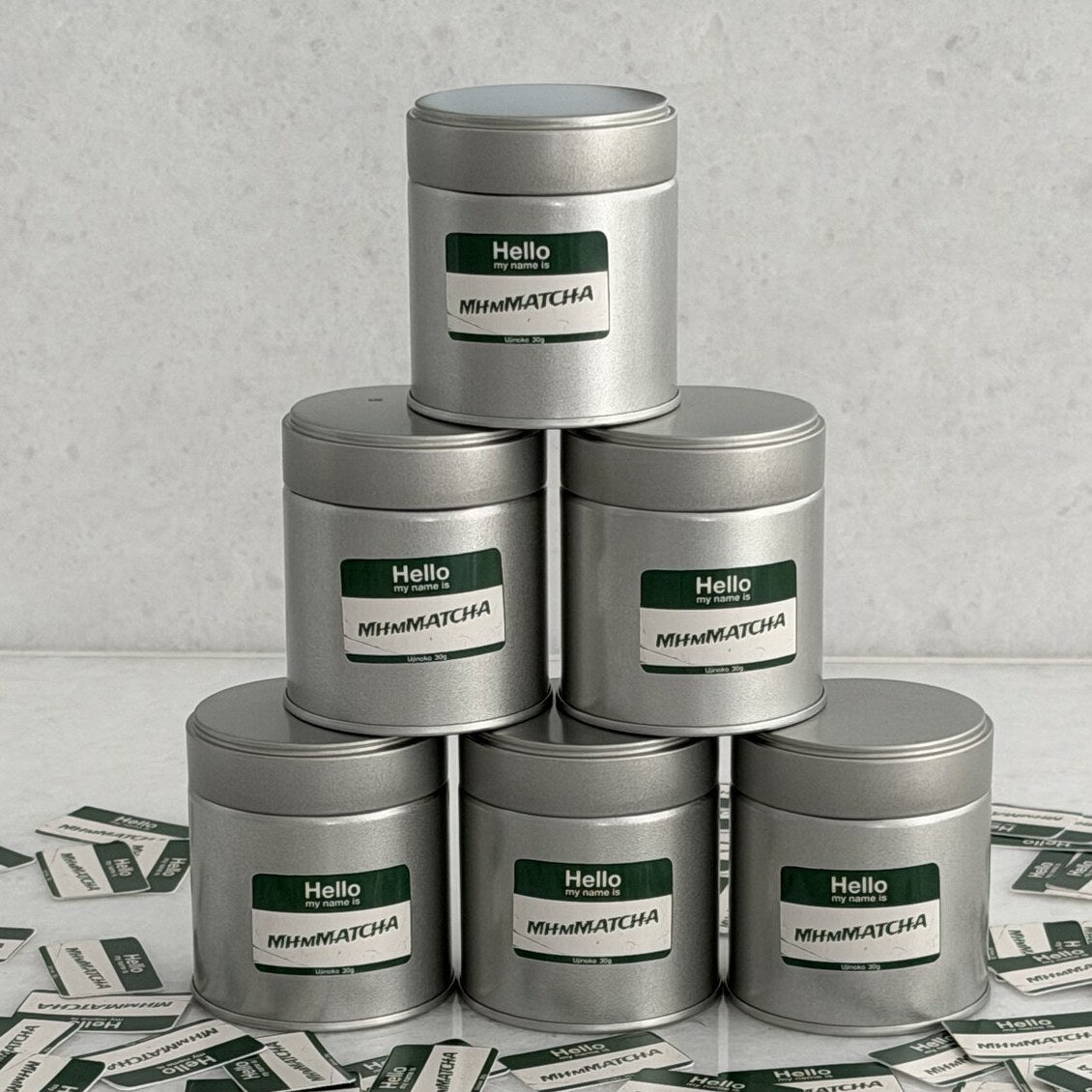 MhmMATCHA ceremonial matcha tins stacked in a pyramid with name-tag stickers